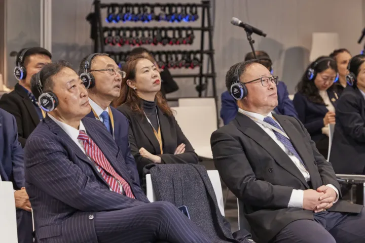 Chinese delegation with interpreting headphones following the talks