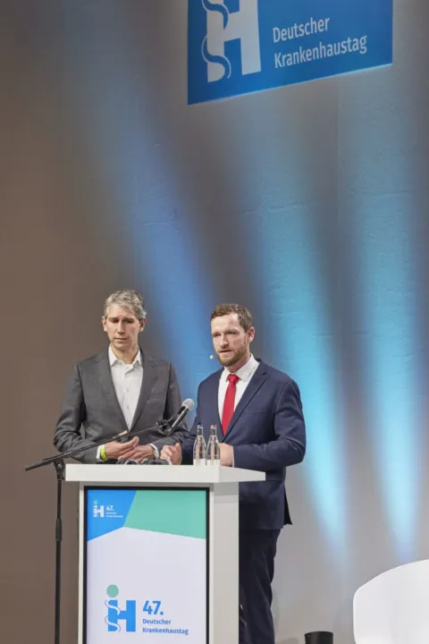 Two speakers together at the lectern of the German Hospital Day