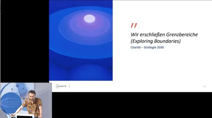 Charité presentation slide "Exploring Boundaries" with a remote speaker