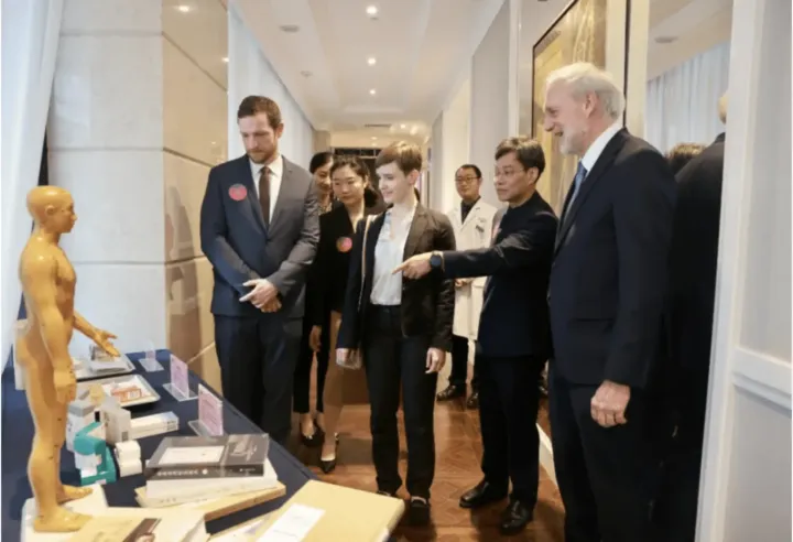 Delegation touring a TCM exhibition with an acupuncture model
