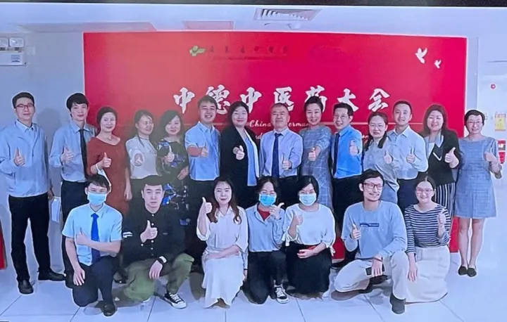 Group photo of the Chinese team in front of the German-Chinese TCM Conference banner