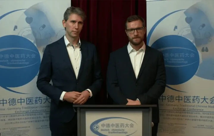 Two hosts at the lectern of the 2021 TCM Conference in Berlin