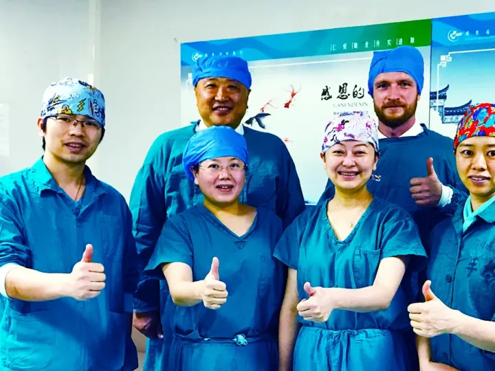 German-Chinese operating theatre team giving a thumbs up